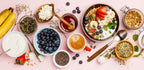 Frühstückstisch mit Beeren, Joghurt, Granola, Honig und Kaffee